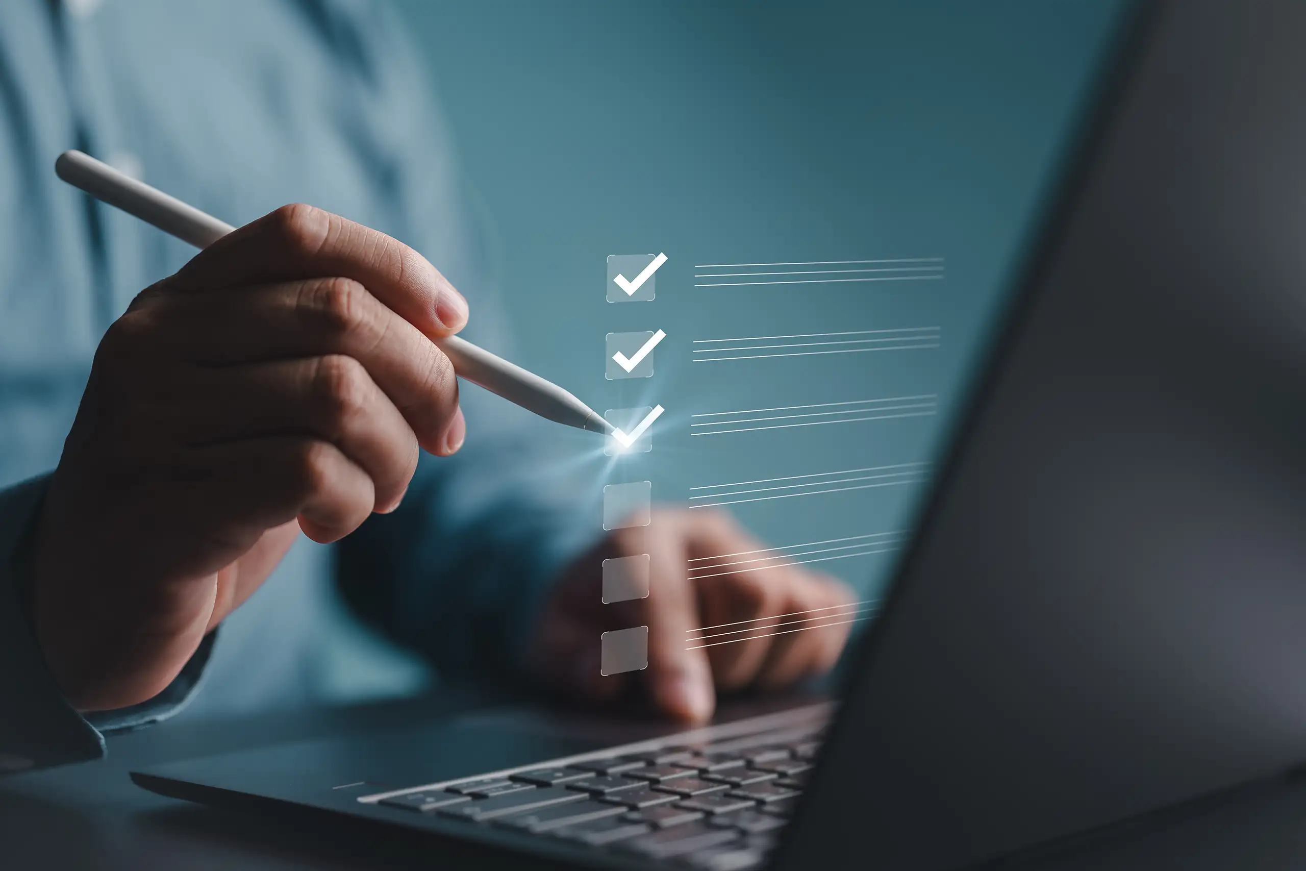 Person in front of a laptop using a stylus to point to an overlaid graphic with 3 unlabelled checkmarks