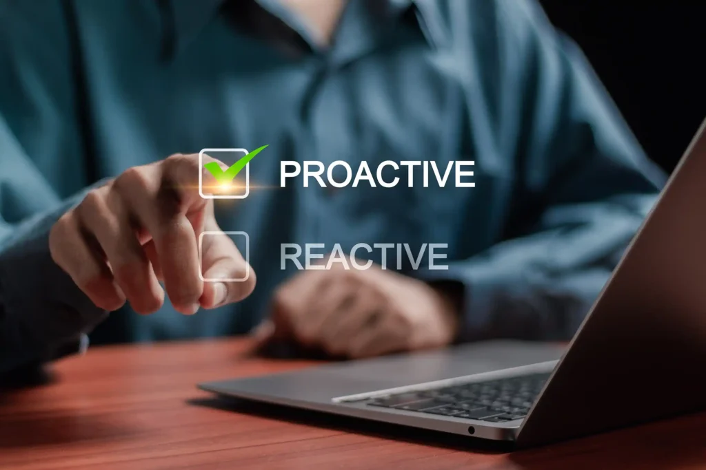 Man on desk with laptop pointing to a graphic with a checked proactive checkbox, the other checkbox is unchecked and is labelled reactive