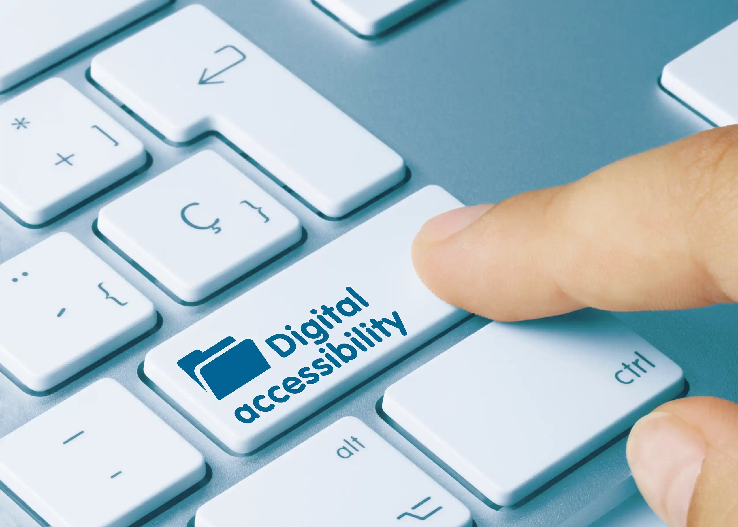Finger pressing a white key on a computer keyboard labelled 'Digital accessibility'