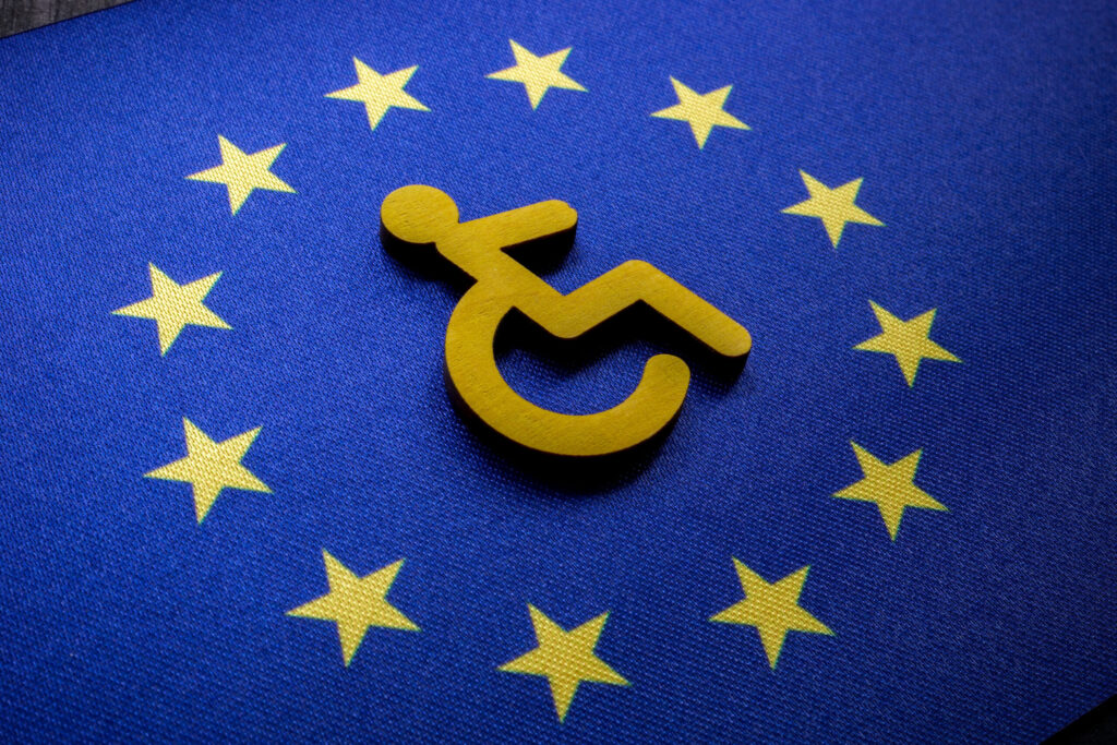 Yellow wheelchair accessibility symbol centered on the European Union flag, surrounded by twelve gold stars on a blue background.