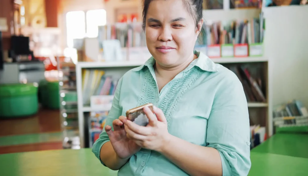 Smiling blind lady interacting with the accessibility features on her smartphone